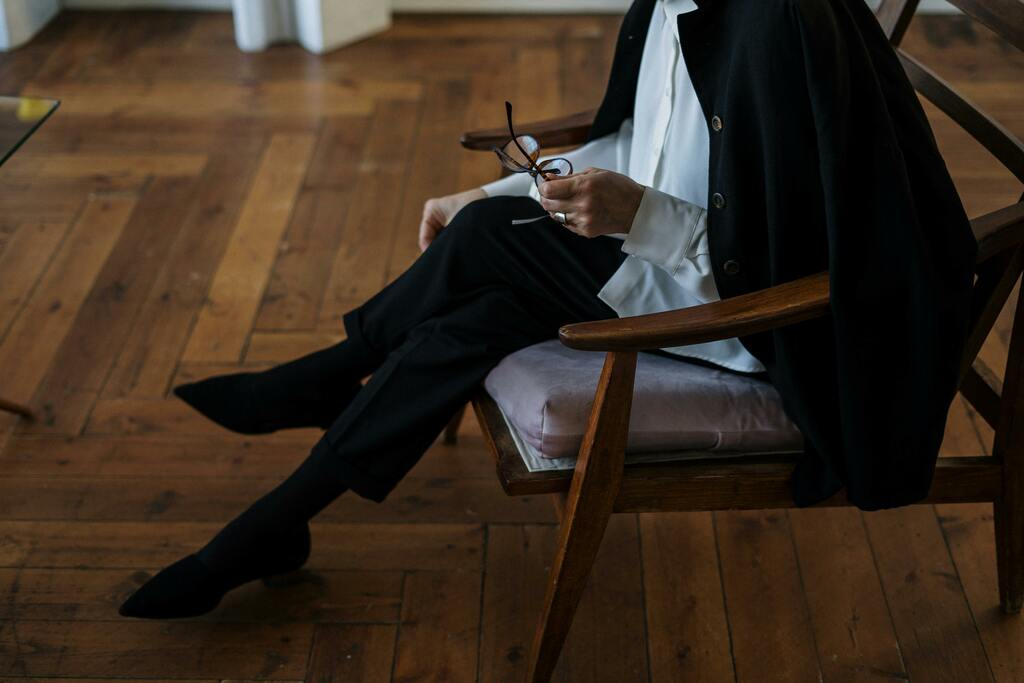 A woman seated indoors, professional and calm